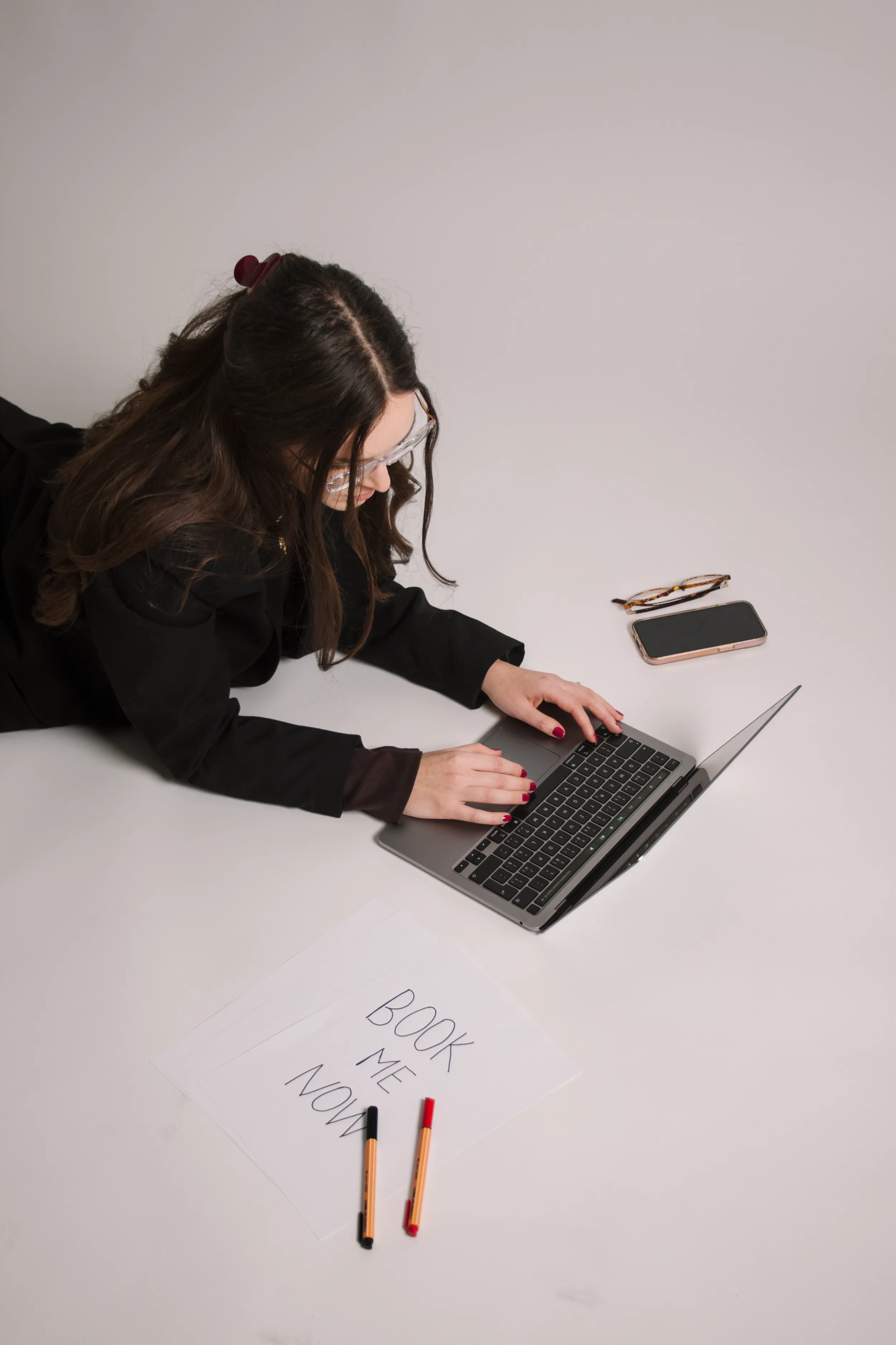 Plánování a rezervace u notebooku, vedle cedule s nápisem Book me now.